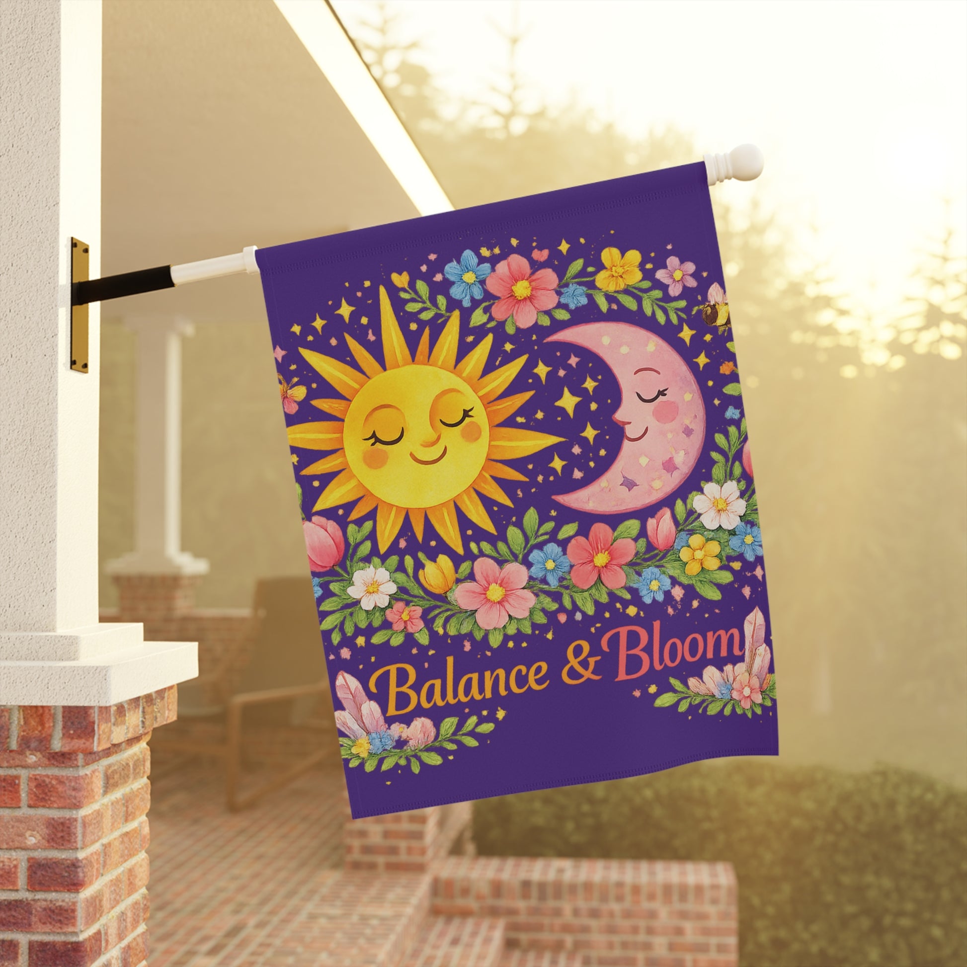 Decorative garden flag with sun, moon, and flowers on a porch