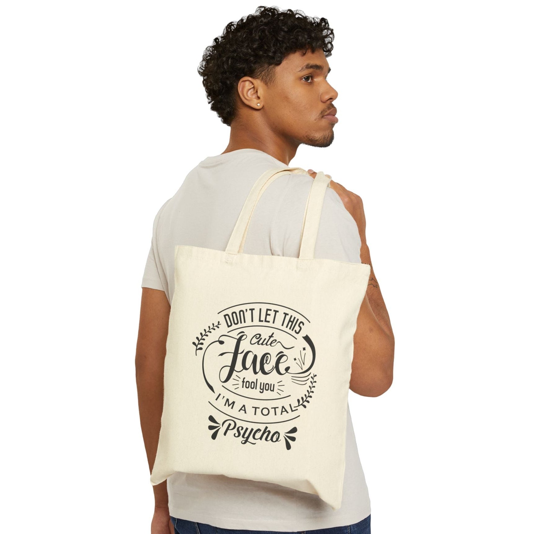 Person holding a tote bag with an illustration of a character on a plain background
