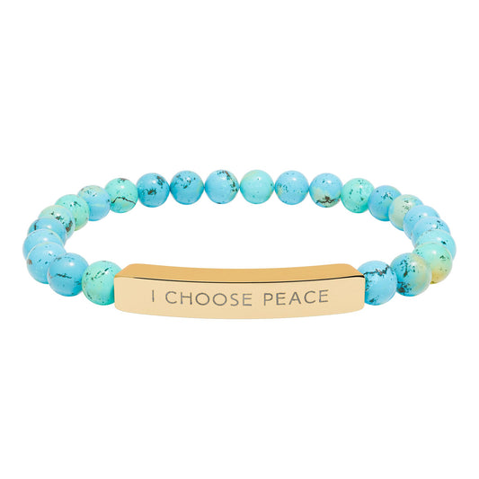 Turquoise beaded bracelet with a gold tag on a white background